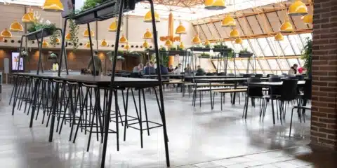 FourReal® 74 high tables with A-frame Room In Room planters in a large canteen