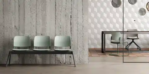 Modern commercial office meeting room featuring an oval wooden table and six green cantilever chairs against a light oak storage wall.
