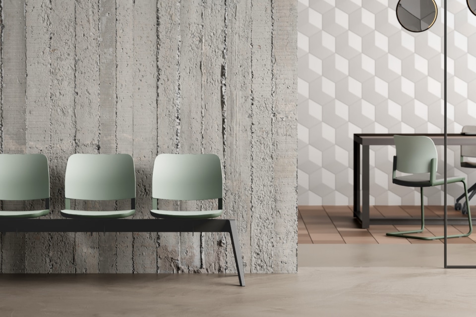 Modern commercial office meeting room featuring an oval wooden table and six green cantilever chairs against a light oak storage wall.