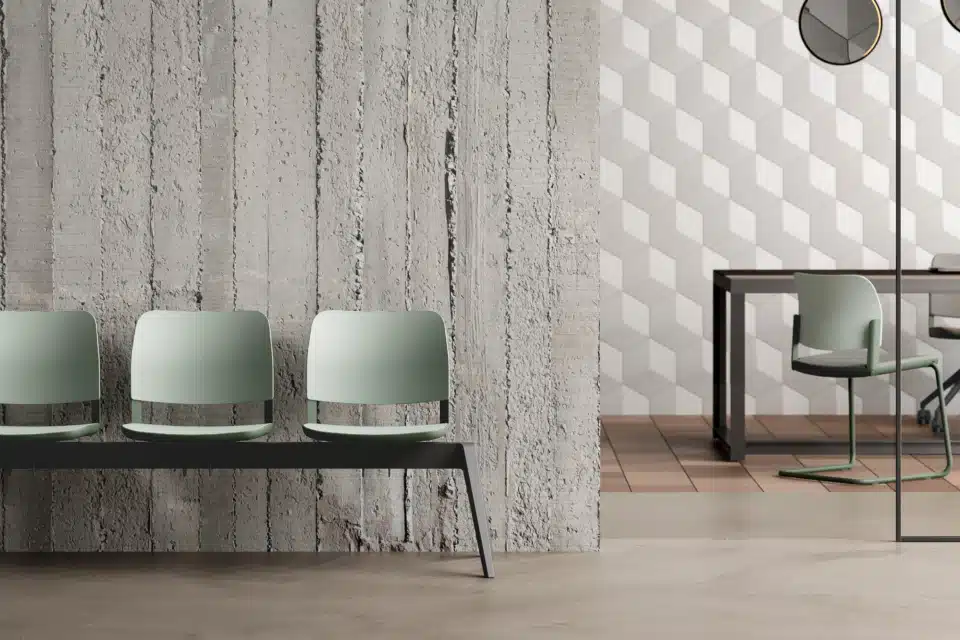 Modern commercial office meeting room featuring an oval wooden table and six green cantilever chairs against a light oak storage wall.