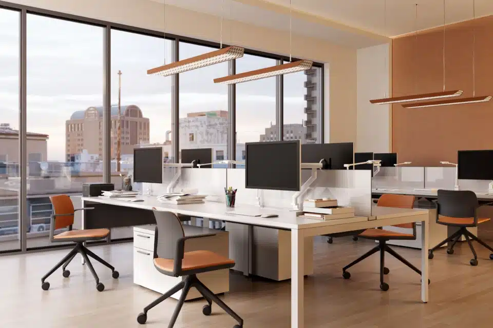Ciao height-adjustable mobile office chair with orange upholstery and black frame in a modern open plan workspace by iQ Workspace.