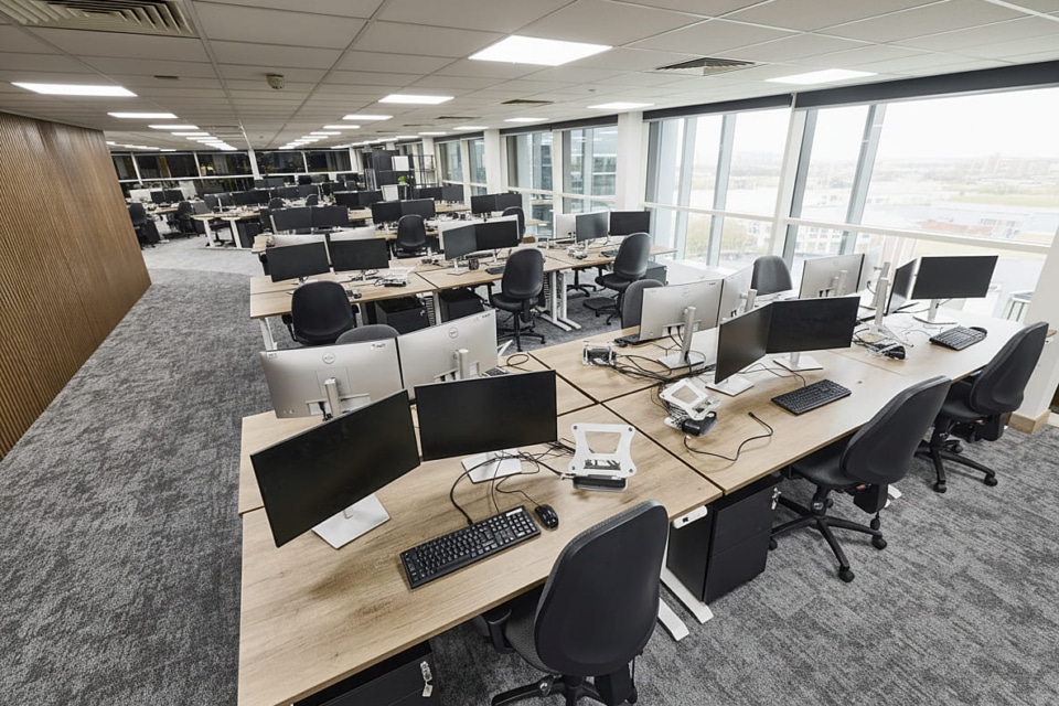 Elevated view of the refurbished MSC Ipswich open-plan office featuring rows of Imperial sit-stand desks, Tick ergonomic chairs, and a bespoke wood-panelled wall.