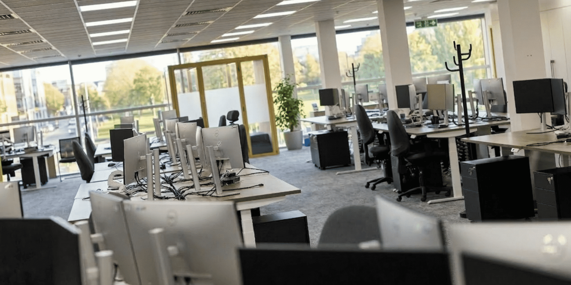 Refurbished MSC Ipswich office interior featuring Imperial sit-stand desks in Nebraska Oak, charcoal high-back chairs, and two Silen Space acoustic pods.
