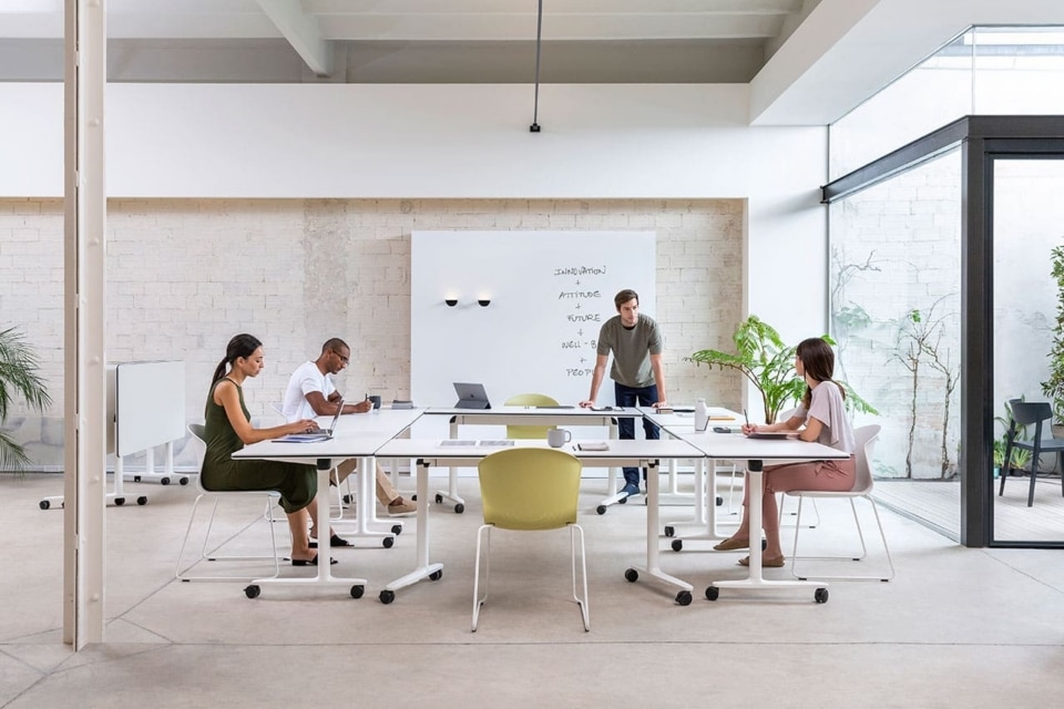 Professional collaborative training space featuring flexible white Talent tables arranged in a U-shape, paired with ergonomic seating for a team meeting.